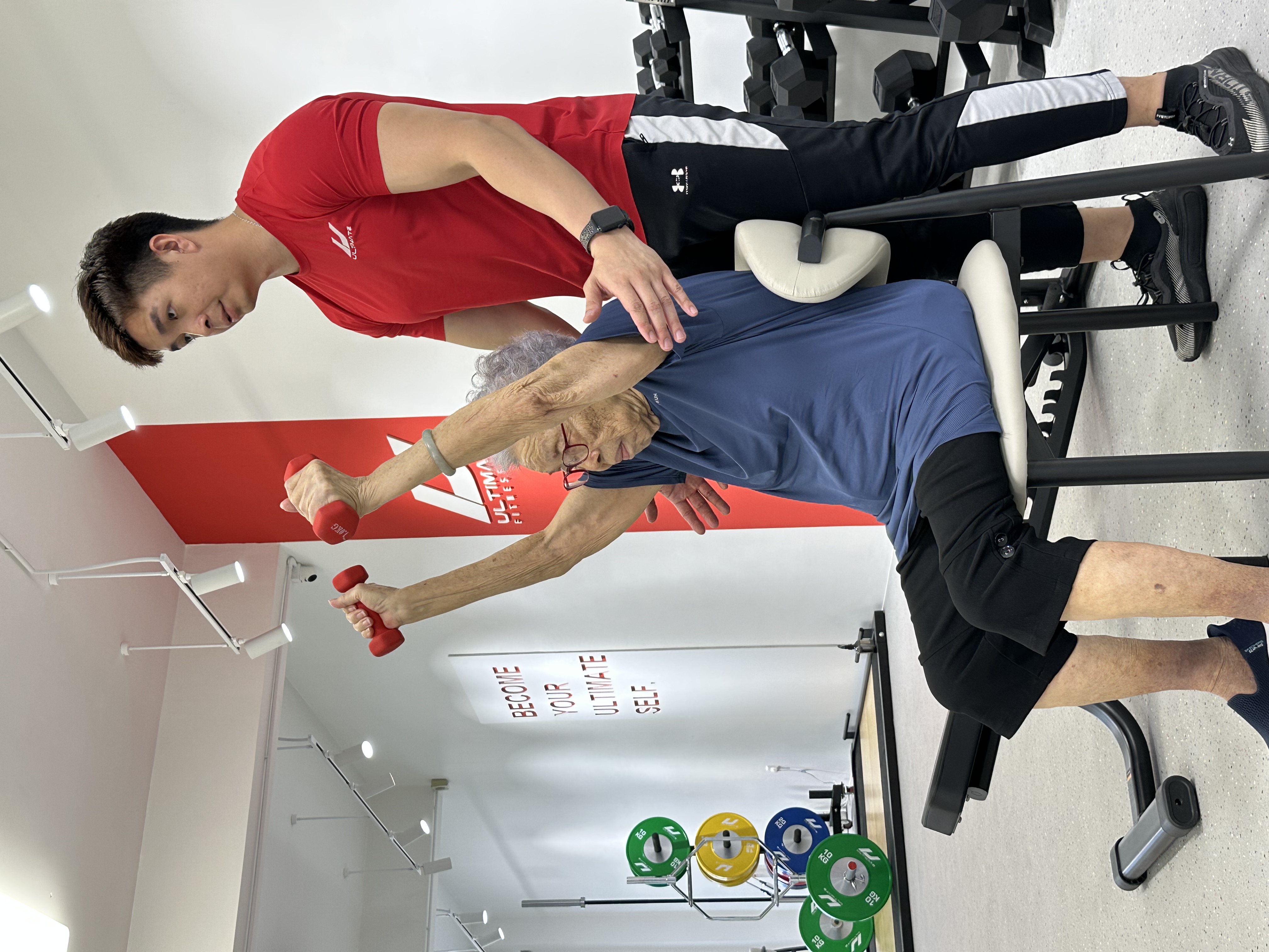 UFL elderly client overhead press guided by coach