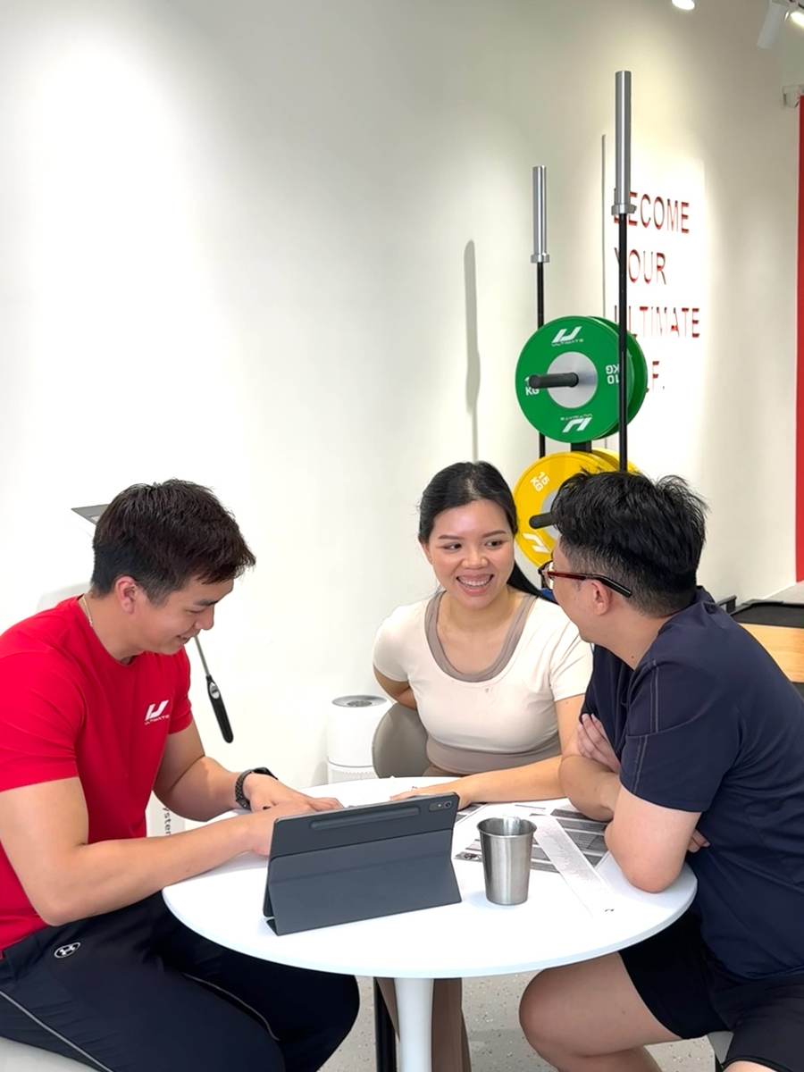UFL coach reviewing programme with clients at consultation table